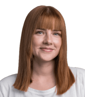 Eine junge Social Media Managerin mit glattem, schulterlangem kastanienbraunem Haar und Pony lächelt sanft. Sie trägt ein weißes Hemd und posiert vor einem schlichten, hellen Hintergrund.