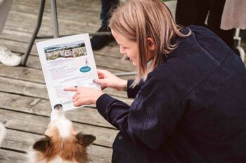 SPiNNWERKerin erklärt Hund Balu das Eventprogramm