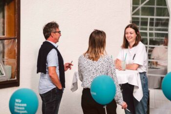 Personen am Stehtisch im Gespräch