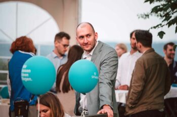 Kunde im Anzug mit zwei SPiNNWERK Ballons