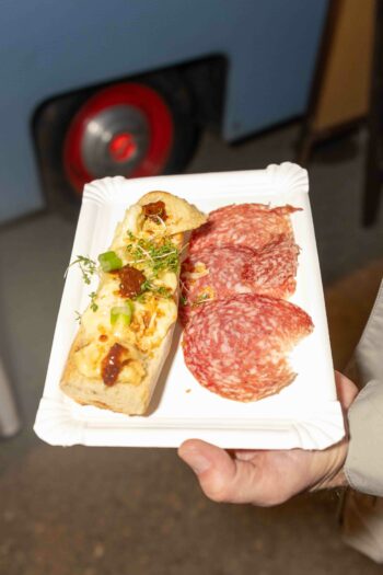 Raclettebrot mit Salami auf einem Pappteller